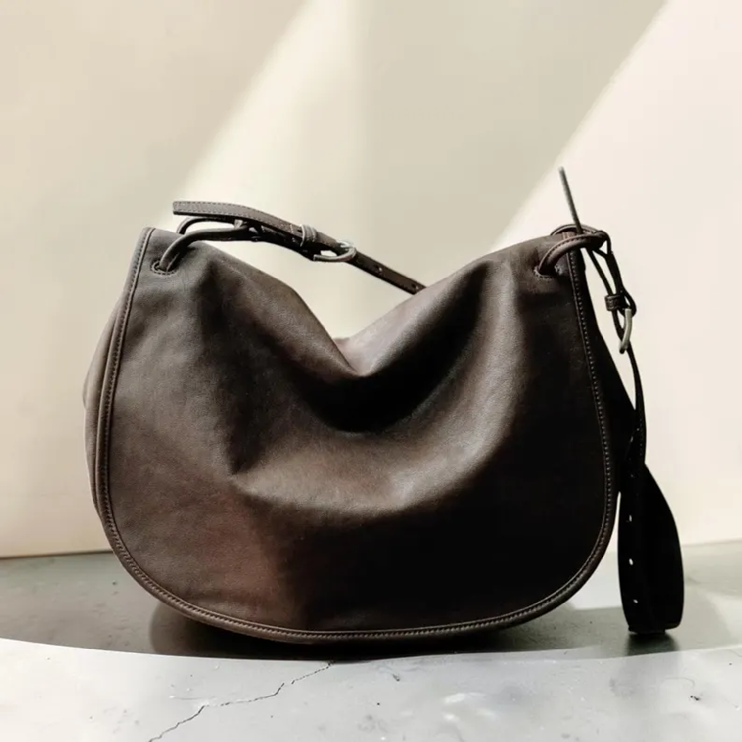 Deep Coffee Brown Soft Draped Saddle Shoulder Pouch With Adjustable Single Hanging Strand, Curved Edge Stitch Detailing And Spacious Unfastened Top Cavity